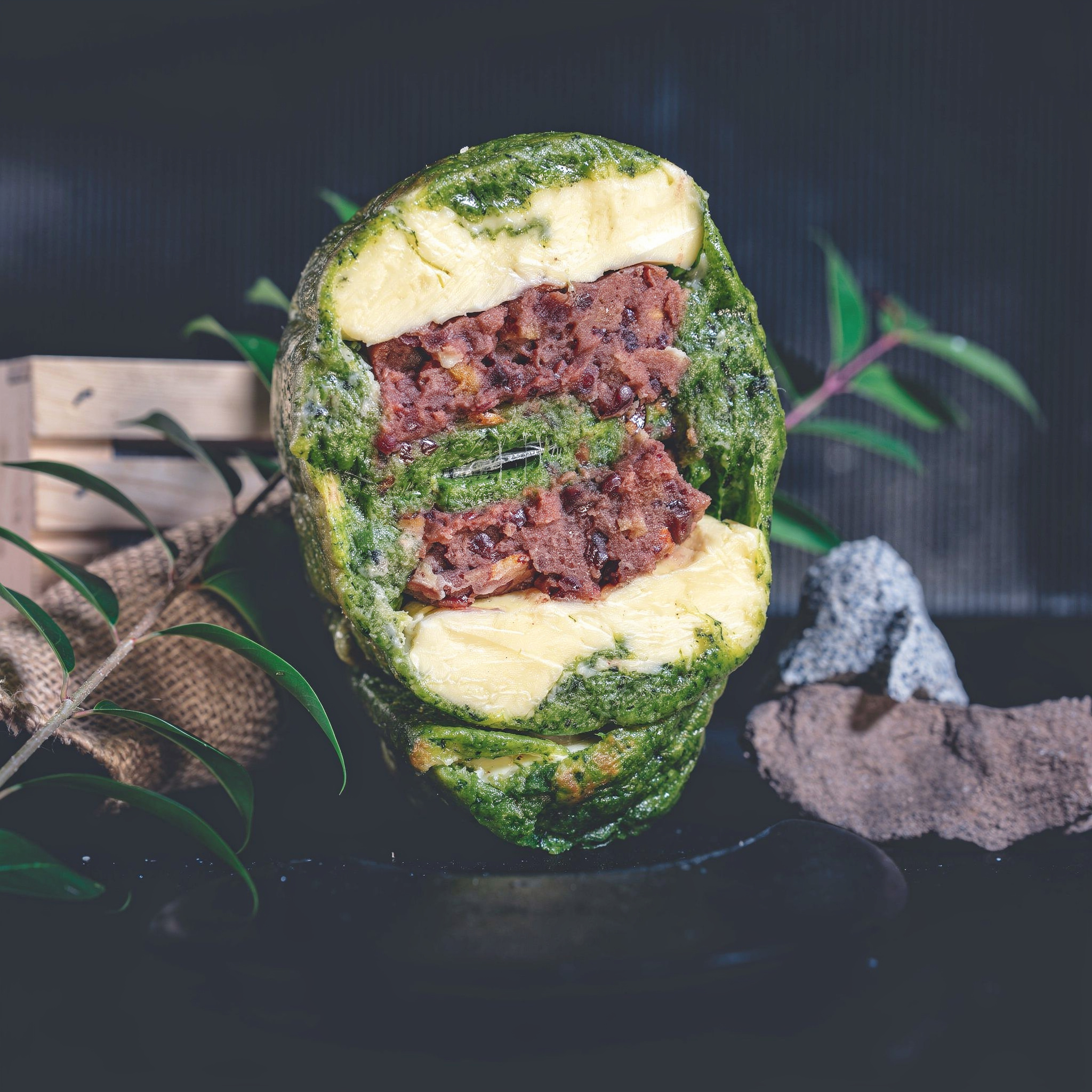 {
  "scene": "A professional food photography scene based on the composition and environment of image 1, where the original bottle is replaced by the pastry from image 2. The setting retains the dark,