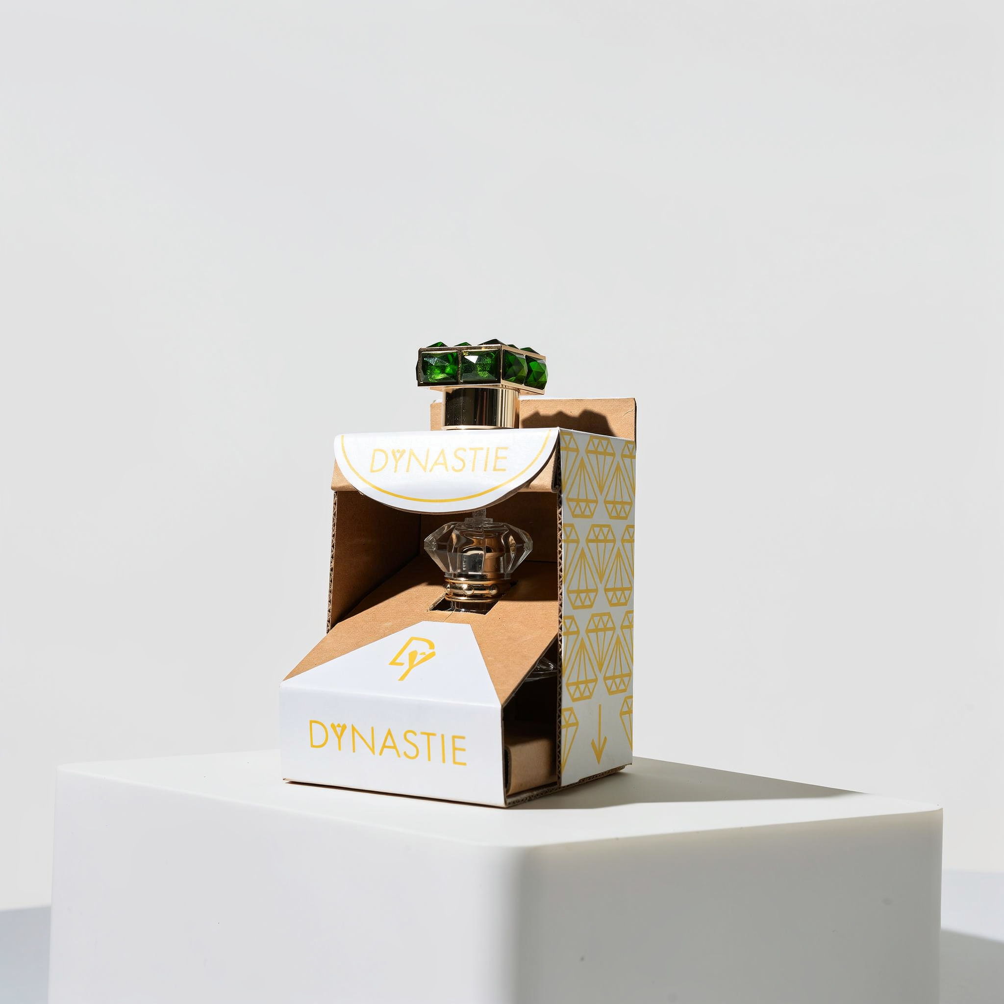 {
  "scene": "A professional high-end commercial product shot where the product packaging from image 2 is placed within the minimalist, bright studio environment of image 1. The scene features the cle