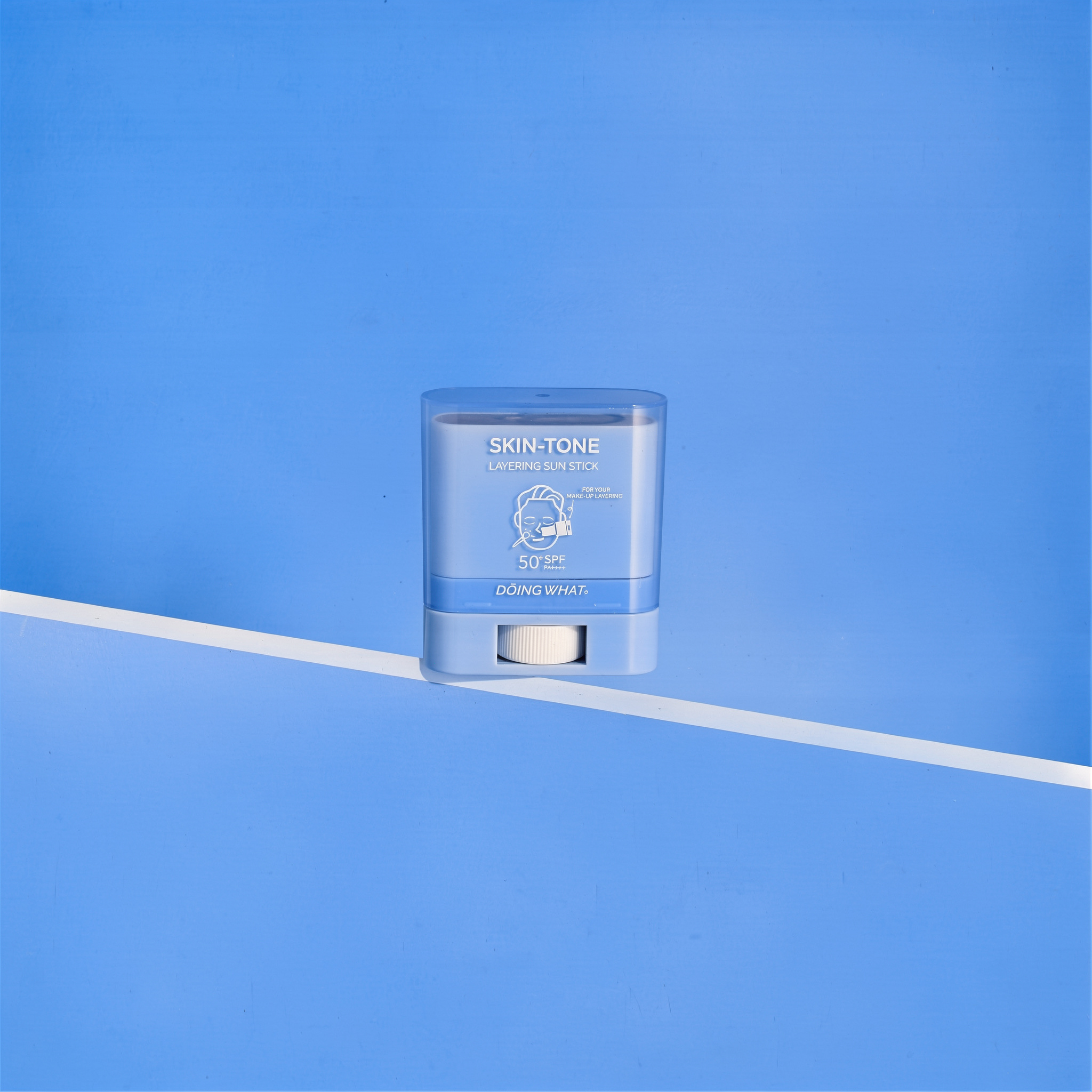 {
  "scene": "A minimalist commercial studio product shot based on the exact environment of image 1. The scene features a flat, vibrant blue background surface divided diagonally from the bottom-left 