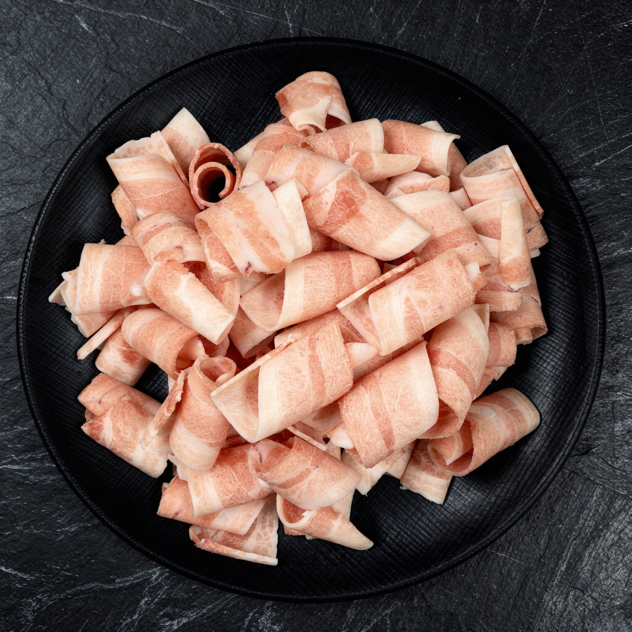 {
  "scene": "A professional, high-end commercial food photography scene featuring the product from image 1 centered on a dark brushed slate countertop, creating a premium culinary aesthetic.",
  "sub